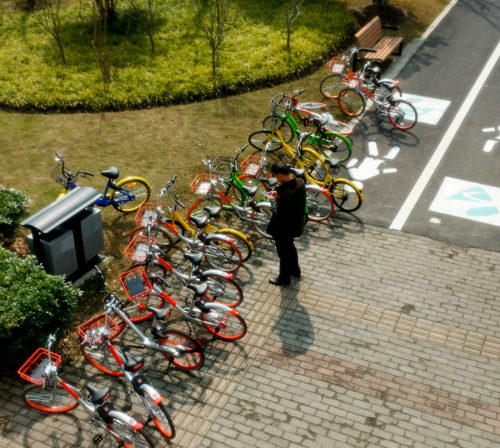 Man standing near share bikes